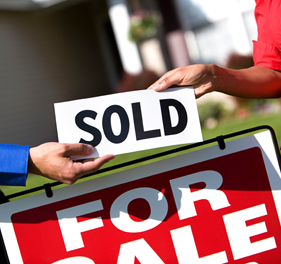 Photo of a sold sign being added to a for sale sign